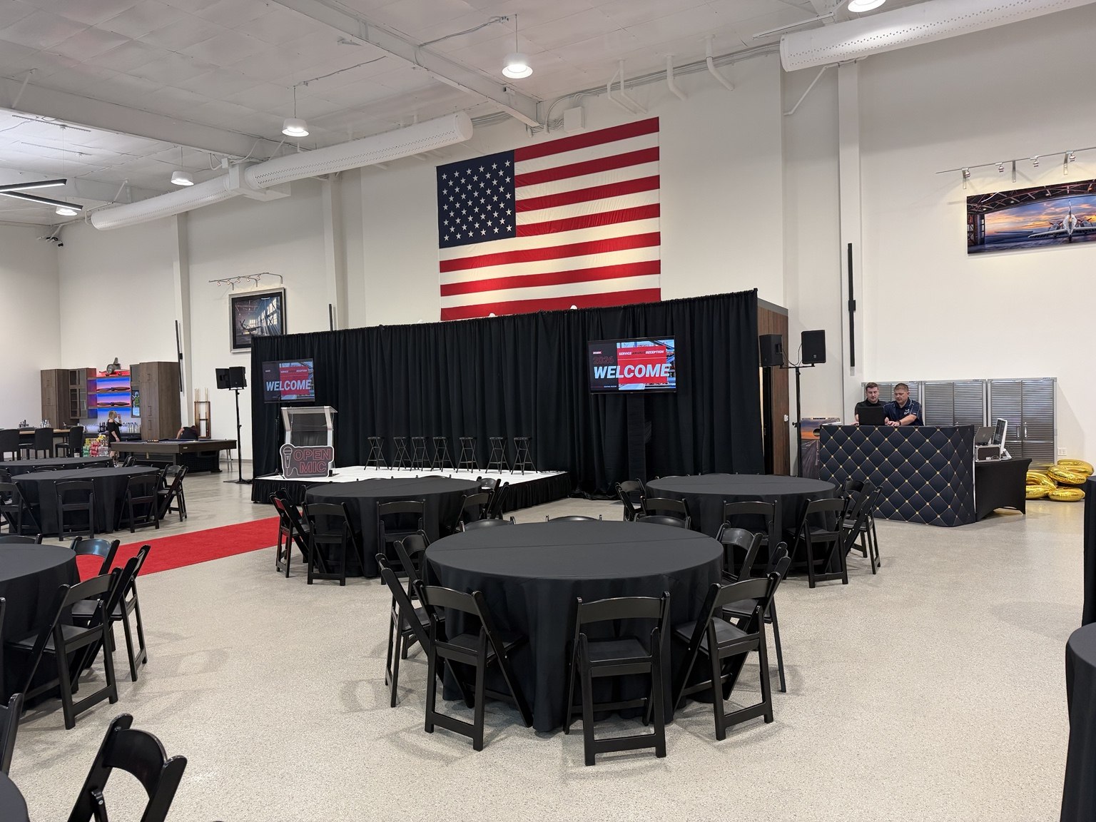 Round dining tables and a stage arranged for an event